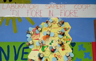 cartellone laboratorio di fiore in fiore in cui sono presenti alcune api fatte con materiali di riciclo