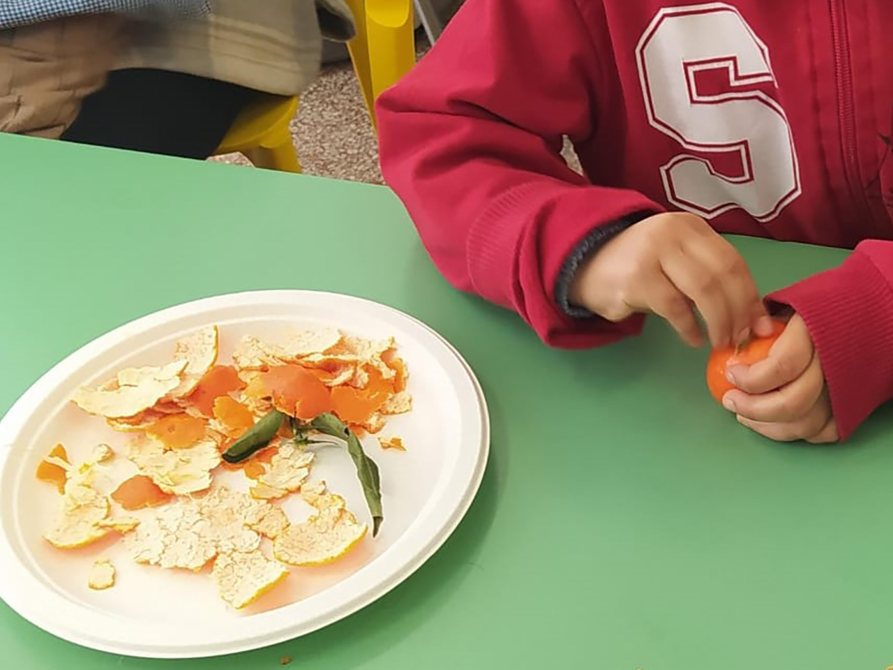 bambino che sbuccia un arancio