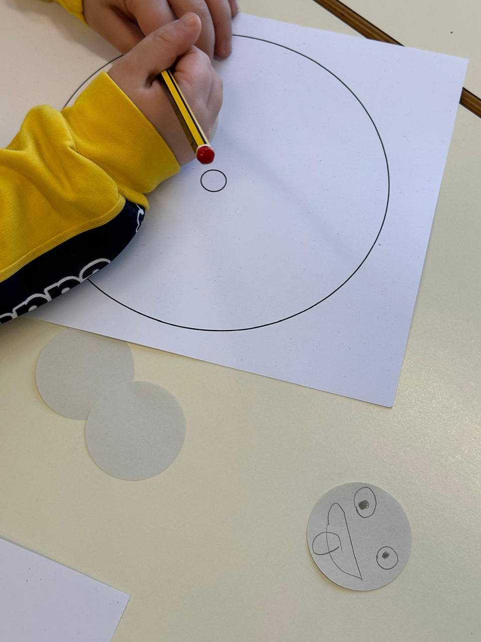 Bambino che si appresta a disegnare cerchio con varie facce con emozioni differenti Bambino che si appresta a disegnare cerchio con varie facce con emozioni differenti