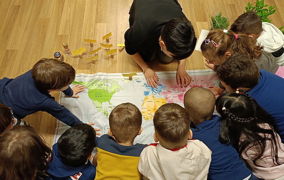 foto di bambini e donna seduti che guardano mappa del mondo foto di bambini e donna seduti che guardano mappa del mondo