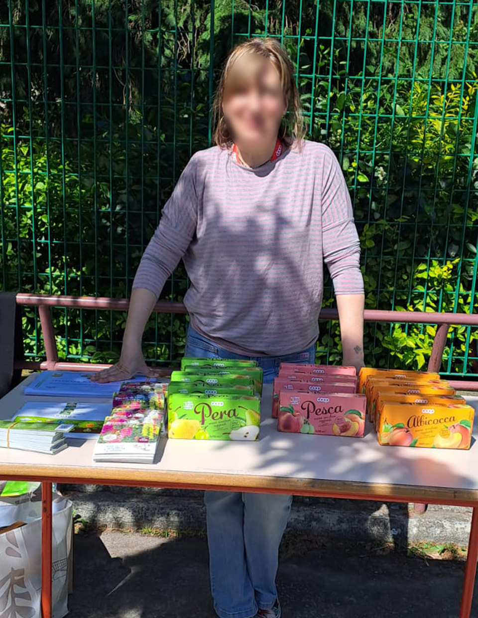 foto di donna cdietroa un banco su cui sono esposti alcuni prodotti attestati e volantini coop foto di donna cdietroa un banco su cui sono esposti alcuni prodotti attestati e volantini coop