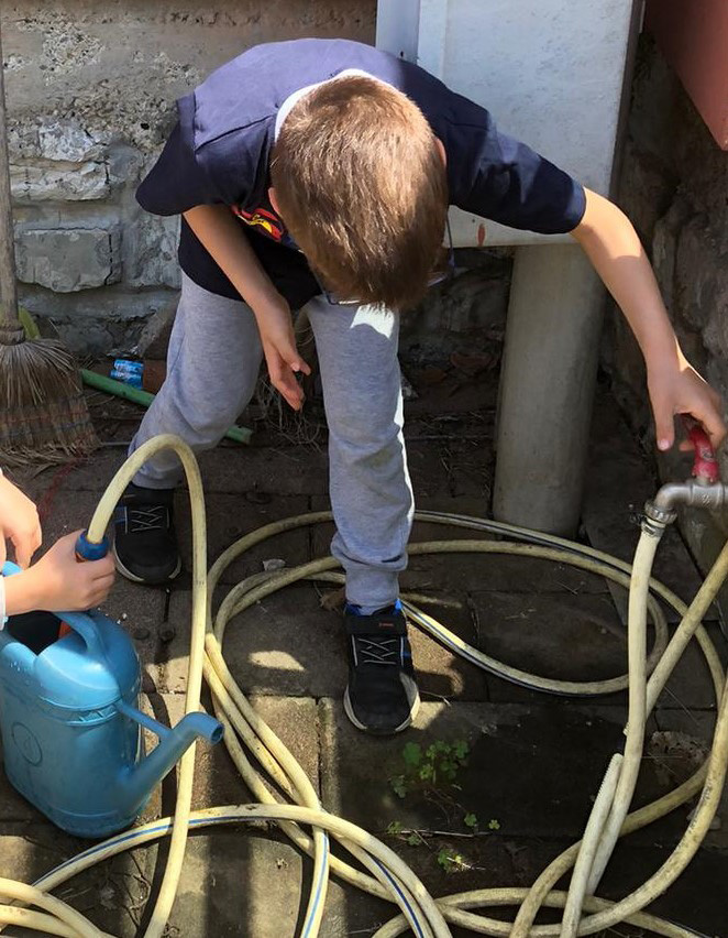 foto di bambini che riempiono annaffiatoio foto di bambini che riempiono annaffiatoio